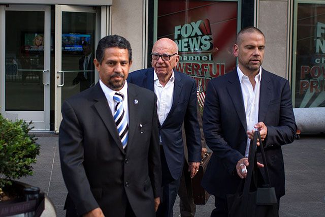 Rupert Murdoch leaving the News Corp. building in July; his son Lachlan Murdoch, who is Executive Co-Chairman of News Corp and 21st Century Fox, is on the right